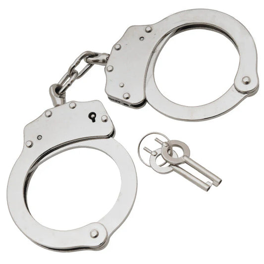 Metallic handcuffs with a key on a white background